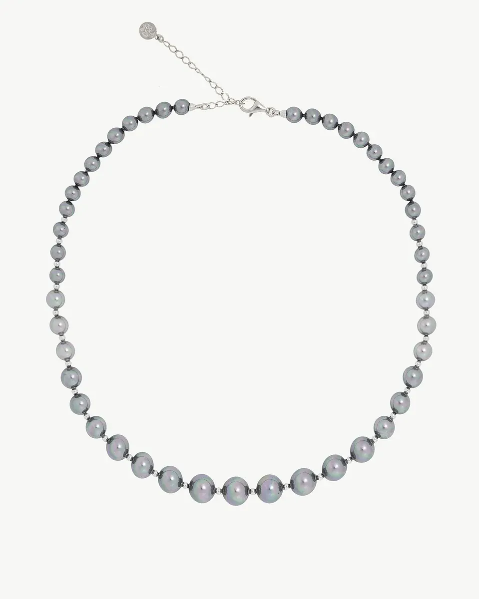 Collar de perlas dispuesto en forma circular sobre fondo blanco, vista frontal completa.