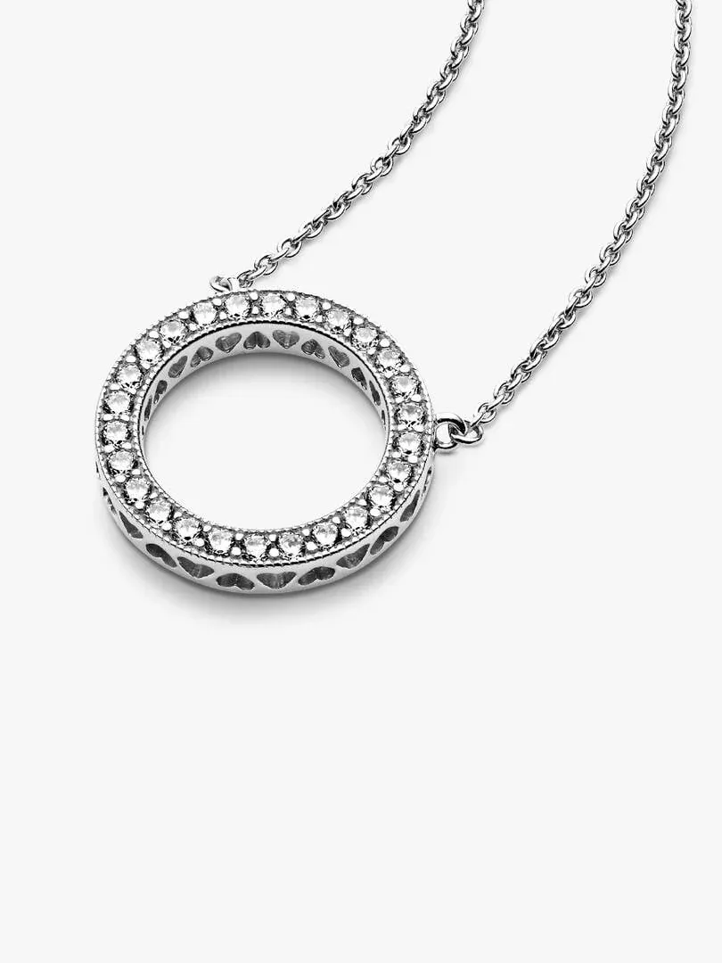 Zilveren ronde hanger met zirkonia aan een ketting, vooraanzicht onder een hoek, witte achtergrond.