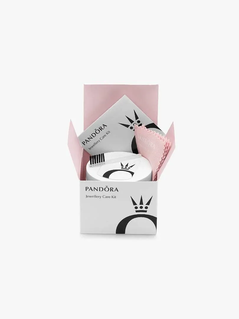 Pandora jewellery care kit in open pink box, front view showing cloth and brush on white background.