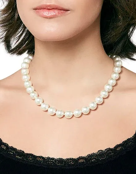 Primer plano del collar de perlas sobre el cuello de una modelo, toma frontal con fondo desenfocado.