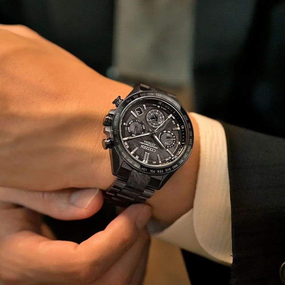 Watch worn on a man's wrist with a white shirt and dark suit, blurred background.