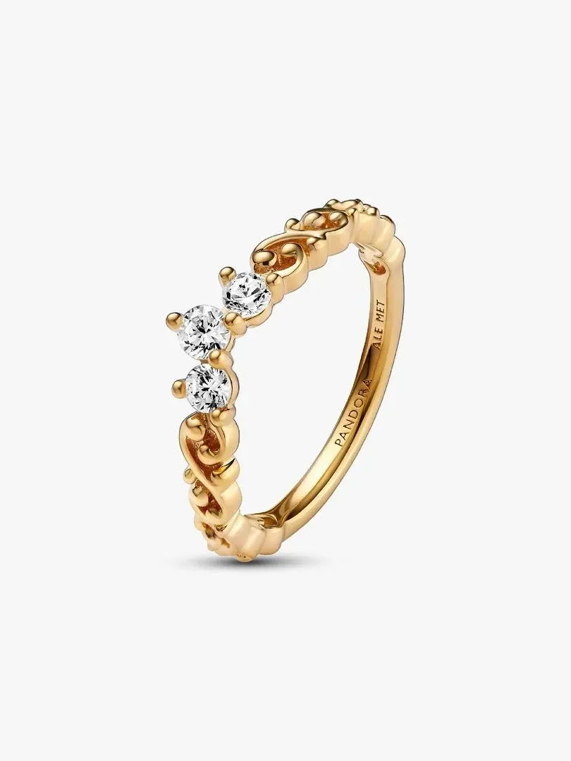 Gold ring with three cubic zirconia stones in relief, angled side view on a white background.