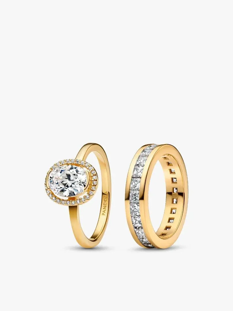 Set van twee vergulde ringen met zirkonia op een witte achtergrond, vooraanzicht vanuit een hoek.