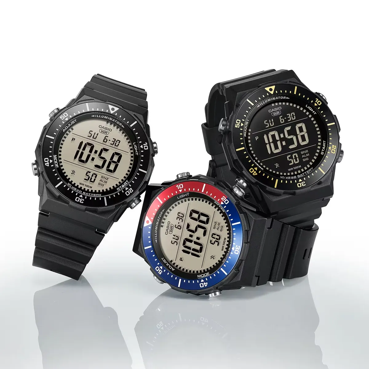 Composición de tres relojes digitales en distintas variantes de color sobre fondo blanco con reflejo.