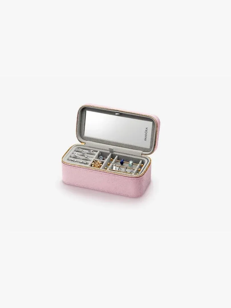 Coffret à bijoux rose ouvert avec compartiments intérieurs, miroir dans le couvercle, fond blanc.