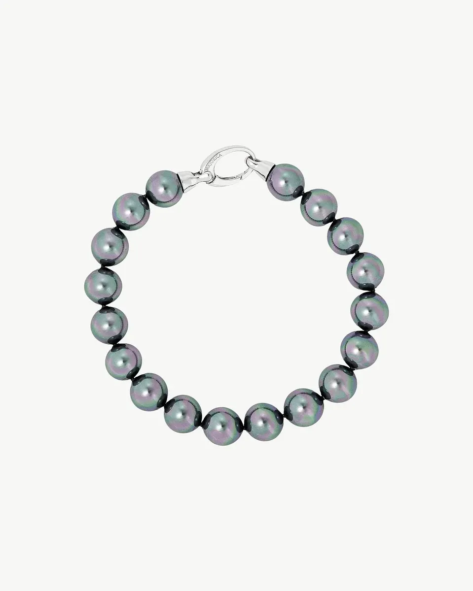Pearl bracelet arranged in a circle on a white background, top view showing the silver clasp detail.
