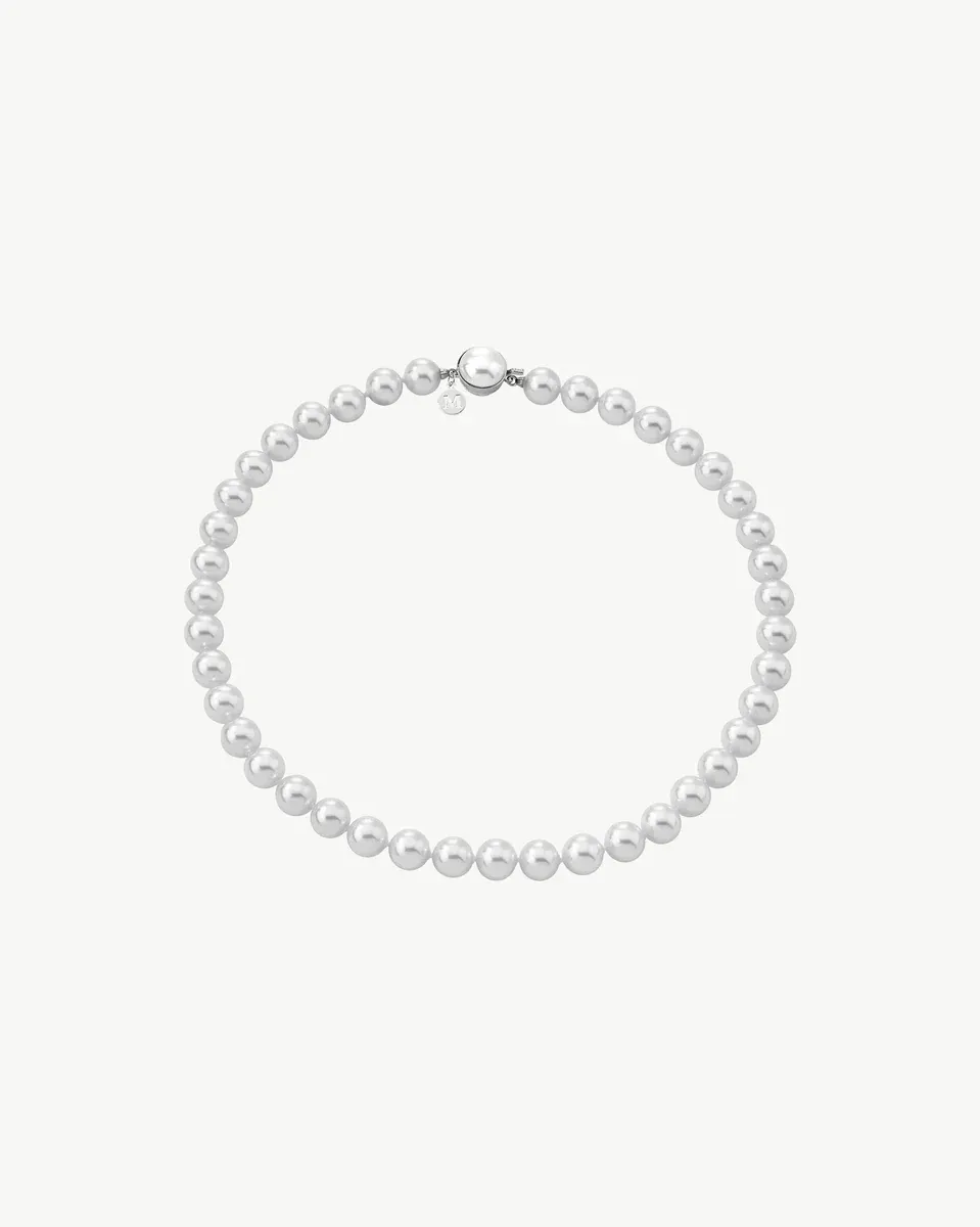 Collar de perlas blancas dispuesto en círculo sobre fondo blanco, vista frontal completa.