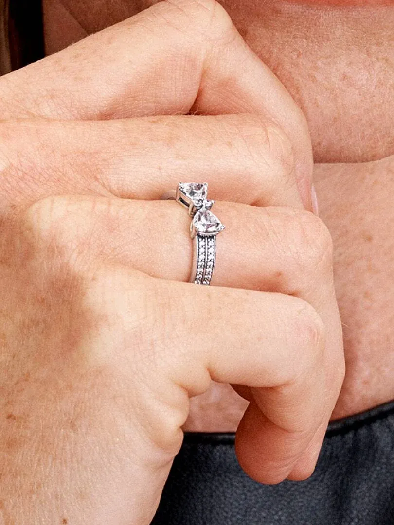 Side close-up of the bow ring with cubic zirconia worn on a finger.