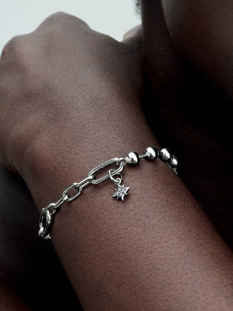 Close-up van de armband met sterhangertje op de huid, zijwaarts aanzicht.