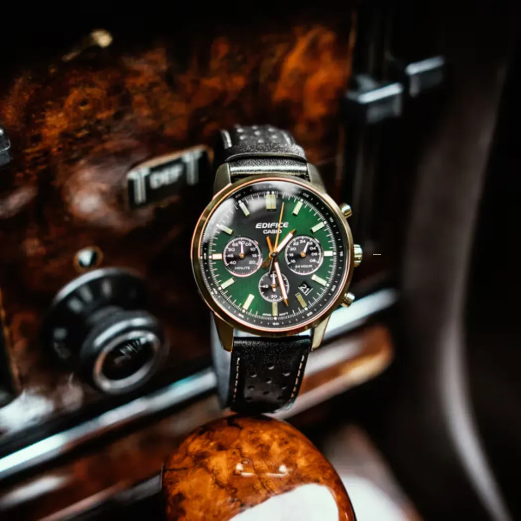 Reloj visto de frente apoyado sobre superficie de madera pulida, fondo de interior de coche clásico.