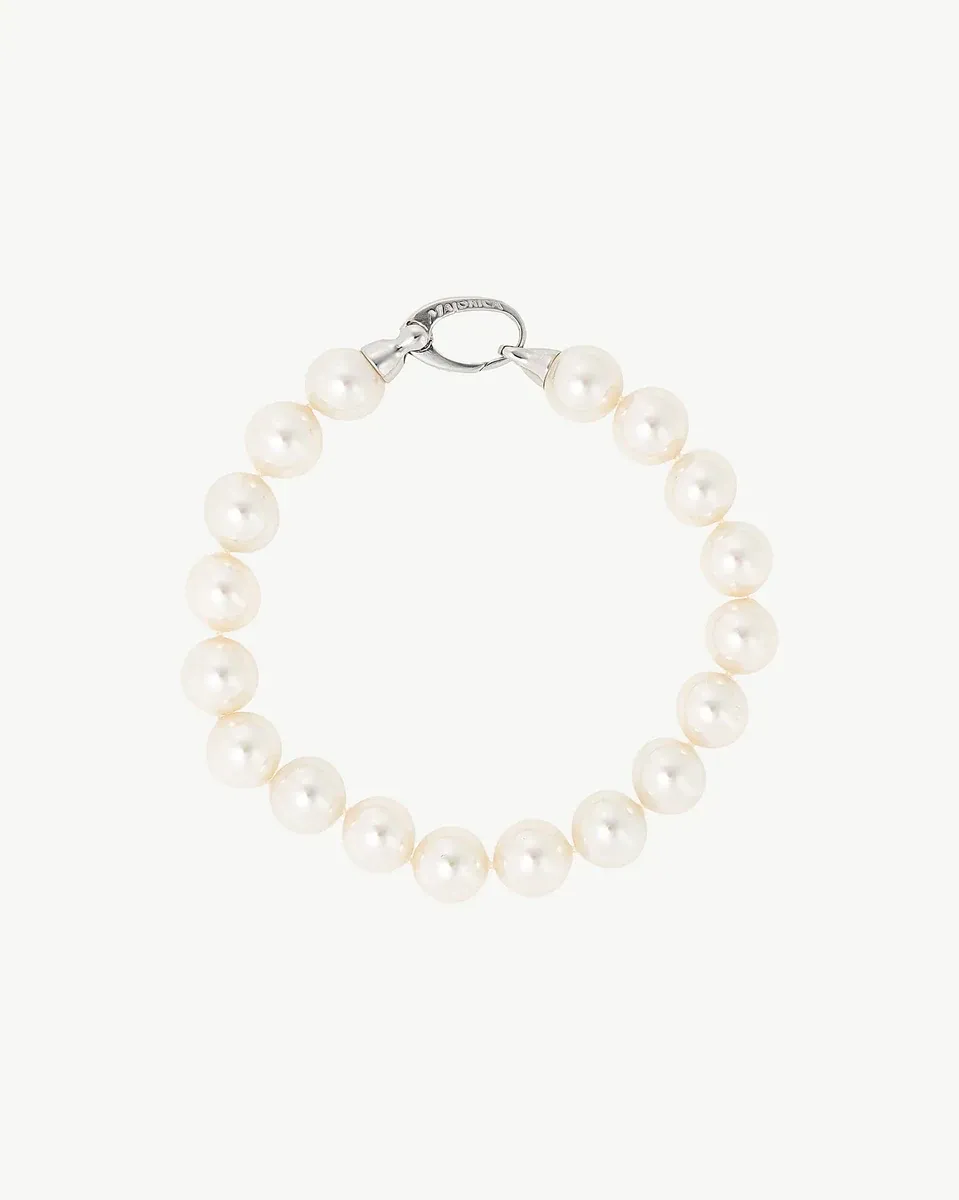 Top view of pearl bracelet in a circular arrangement, neutral white background.