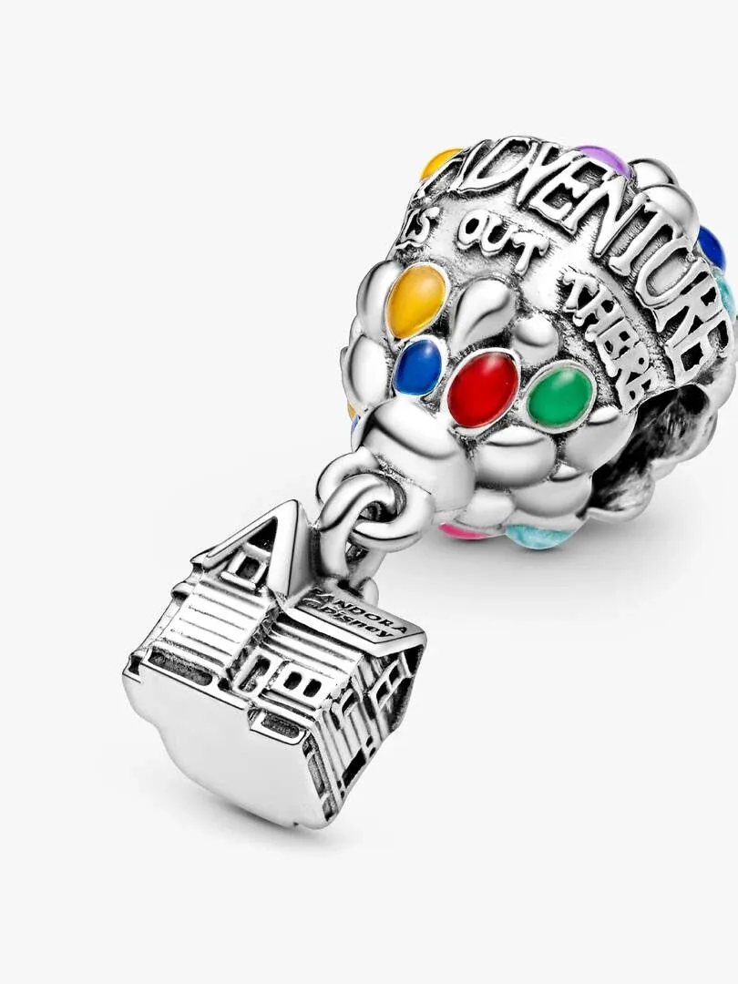 Schuin beeld van charm met geëmailde ballonnen en zilveren huis hanger op een witte achtergrond.