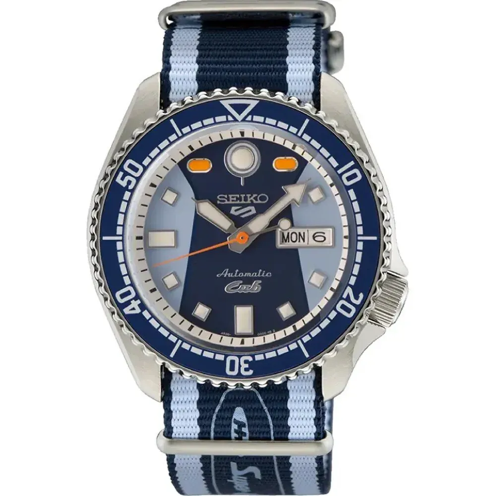 Vista frontal del reloj con esfera bicolor azul, bisel giratorio y correa de tela a rayas sobre fondo blanco