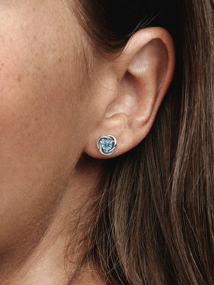 Seitenansicht in Nahaufnahme eines hellblauen Kristallstecker-Ohrrings am Ohrläppchen.