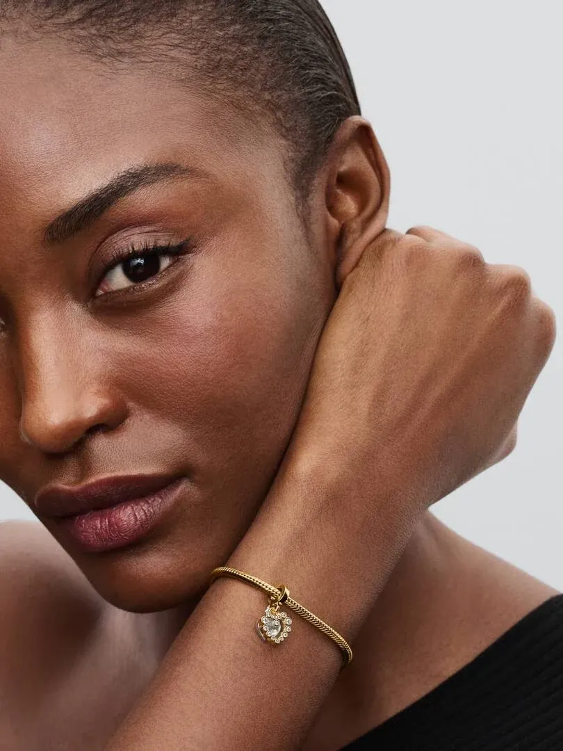 Close-up of the heart charm on a wrist, side view with model against a neutral background.