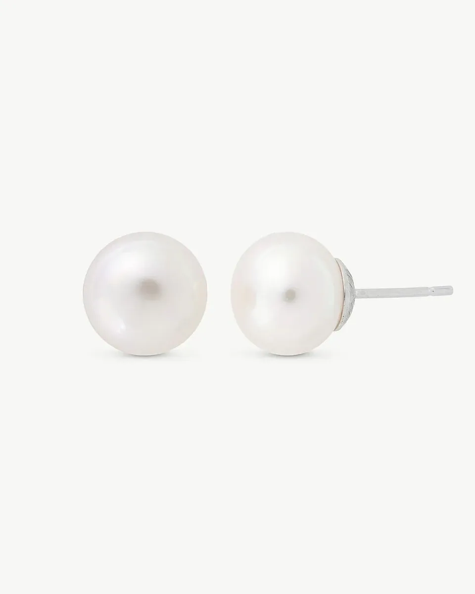 Par de pendientes de perla blanca, vista frontal y lateral con el pincho visible, sobre fondo blanco.