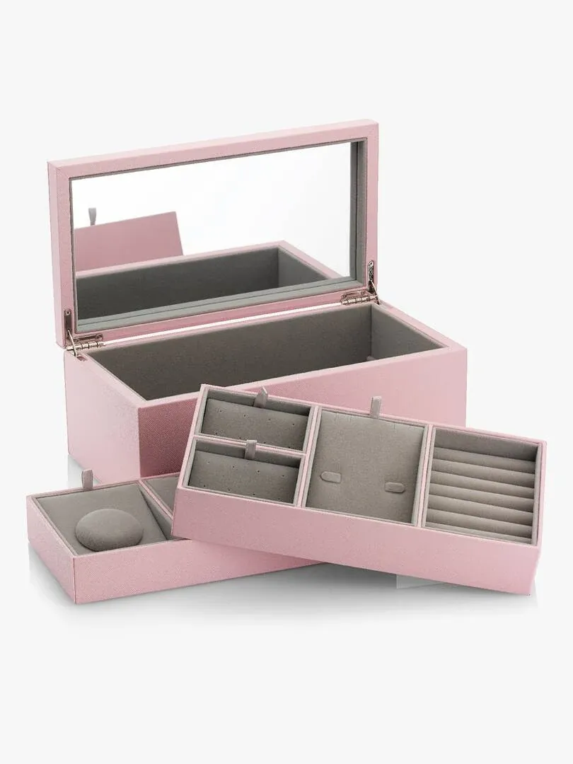 Geöffnetes rosa Schmuckkästchen mit Spiegeldeckel, grauen herausnehmbaren Tabletts auf weißem Hintergrund.