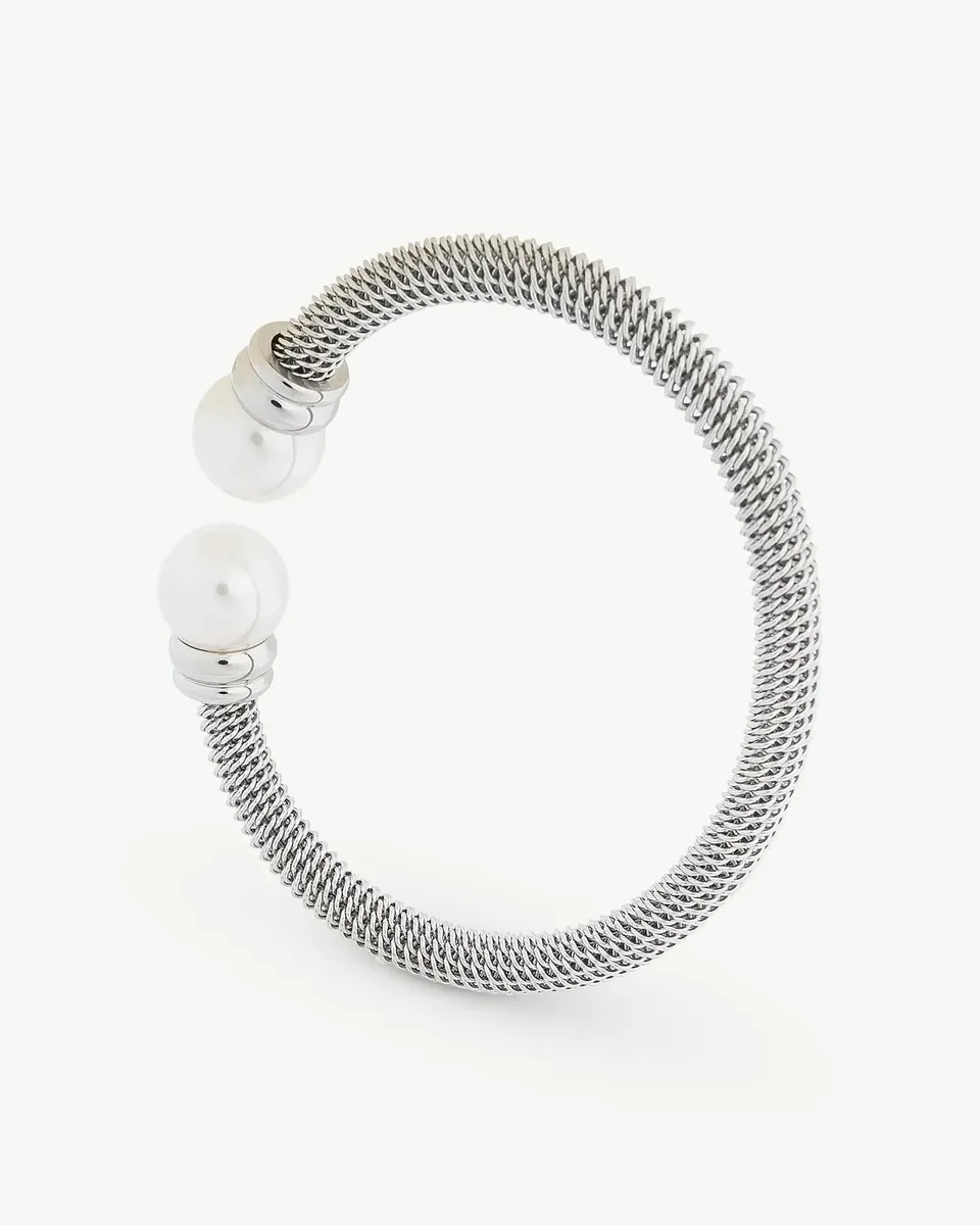Rigid metal mesh cuff with two white pearls at the ends, front view on white background