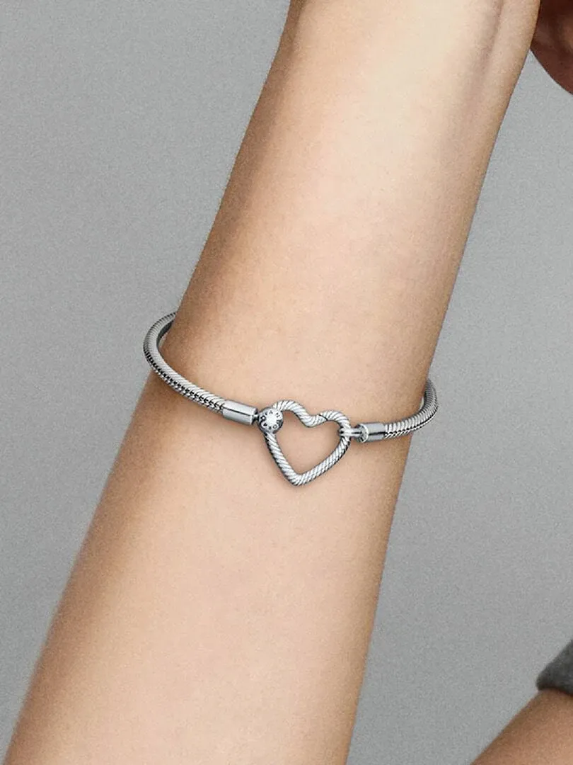 Gros plan du bracelet avec fermoir cœur sur un poignet, vue latérale en angle diagonal.