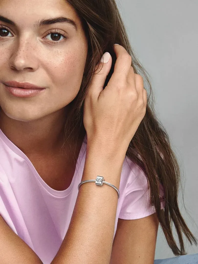 Close-up of the wrist wearing the Disney clip, side view against a blurred neutral background.