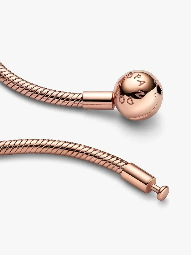 Close-up of the snake chain with engraved ball clasp, neutral white background.