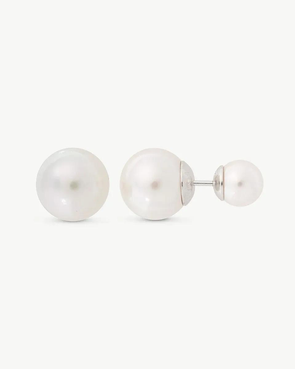 Double pearl earrings shown in profile view on a white background, highlighting the two spheres and silver post.