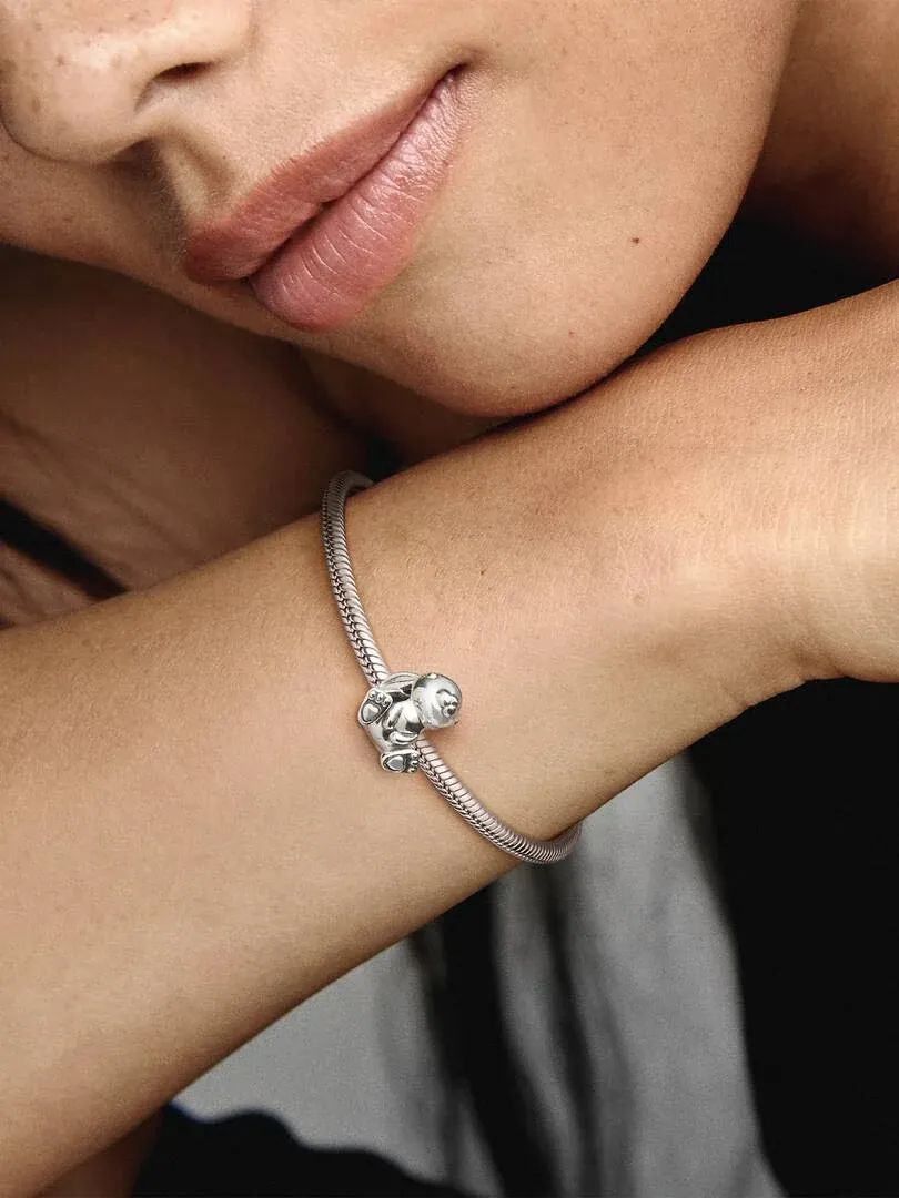 Nahaufnahme des Hasen-Charms an einem Silberarmband am Handgelenk, Seitenansicht.