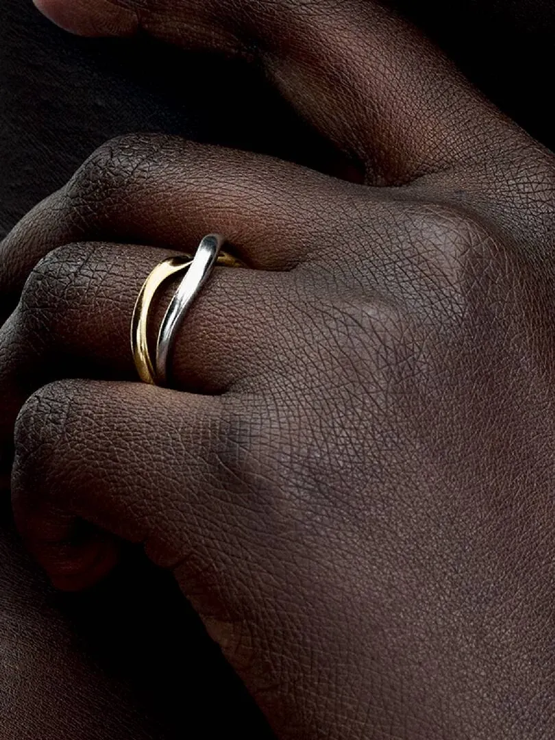 Close-up van de verstrengde bandring om een vinger, zijaanzicht op een donkere huid.