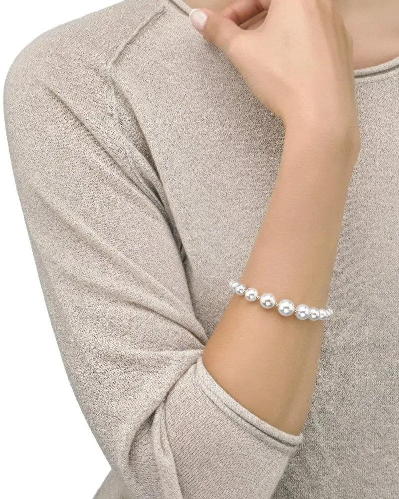 Close-up of the pearl bracelet on a wrist, side view against a beige knit garment.
