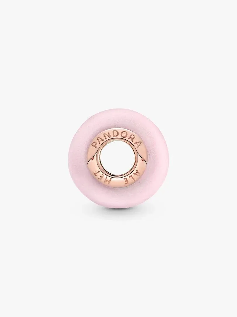 Top-down close-up of the matte pink charm with engraved rose gold core, neutral white background.