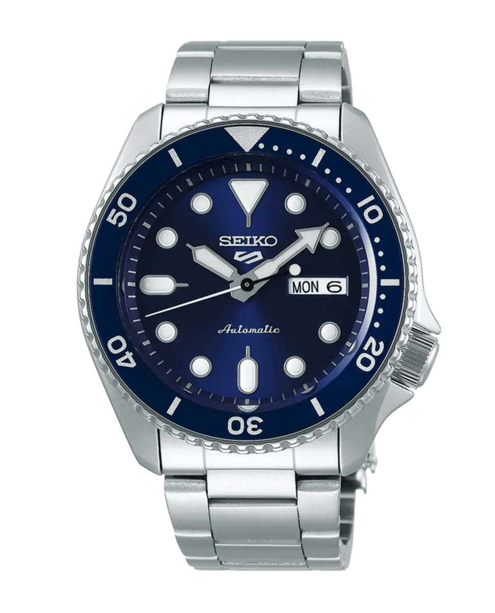 Vista frontal del reloj con esfera azul y brazalete de acero sobre fondo blanco.