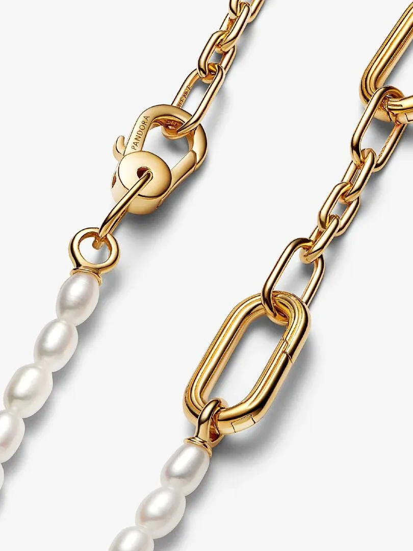 Nahaufnahme des goldenen Karabinerverschlusses und der Perlenglieder auf weißem Hintergrund.