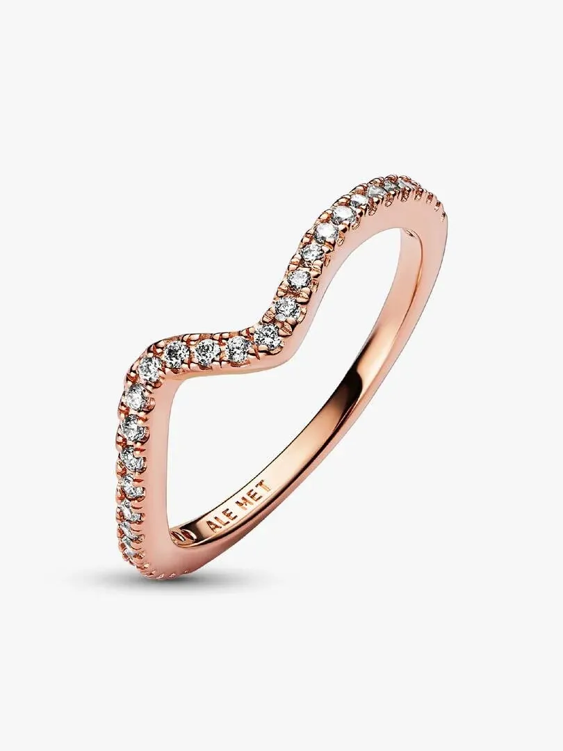 Anillo con diseño ondulado visto en ángulo lateral, fondo blanco, detalle de circonitas incrustadas.