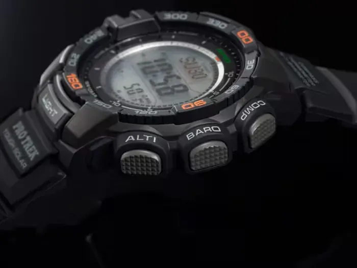 Primer plano lateral del reloj, enfocando los botones de función sobre fondo negro.