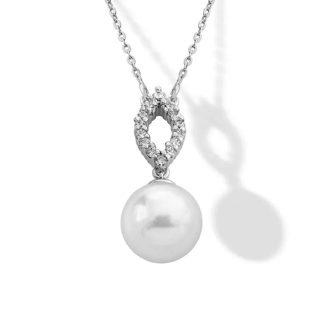 Close-up of the pearl and cubic zirconia pendant on a white background, front view with soft shadow.