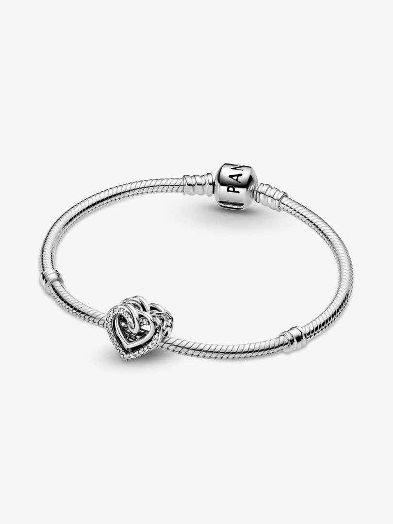 Charm aux cœurs entrelacés sur un bracelet en argent, vue de face sur fond blanc.