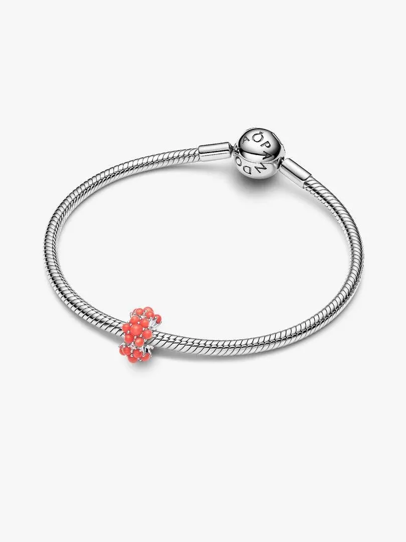 Zilveren armband met rood koraal charm, vooraanzicht onder een hoek op witte achtergrond.