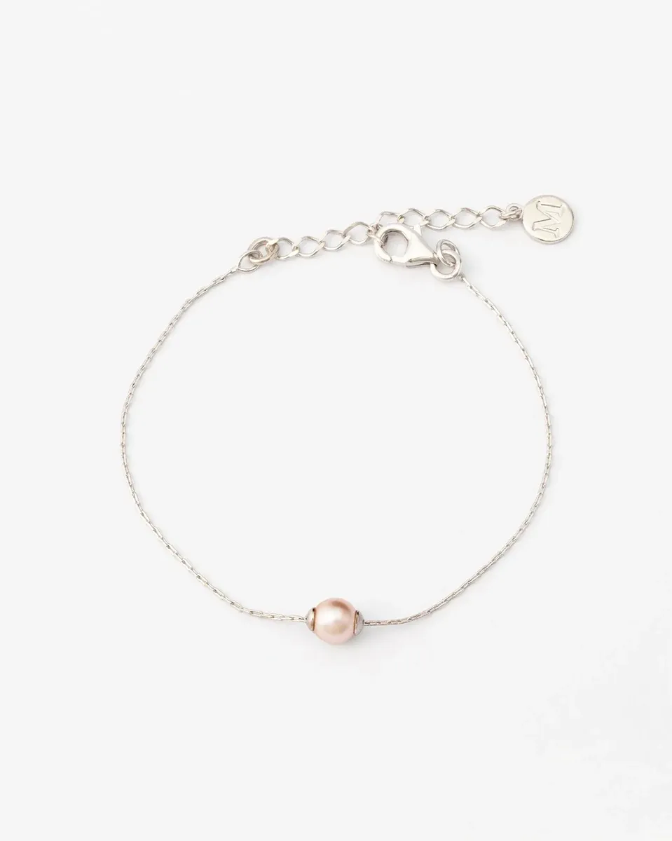 Pulsera de plata con perla rosa vista de frente, sobre fondo blanco, mostrando el cierre y la cadena.