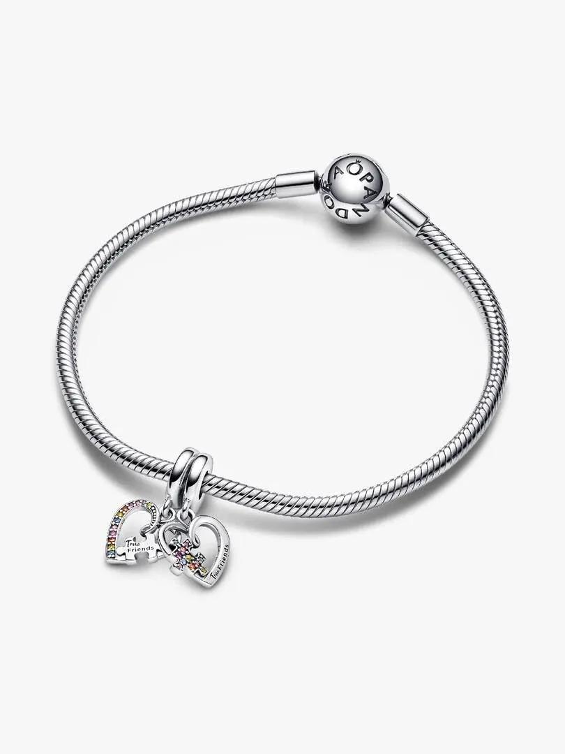 Bracelet en argent avec charms cœur et puzzle, vue diagonale sur fond blanc.