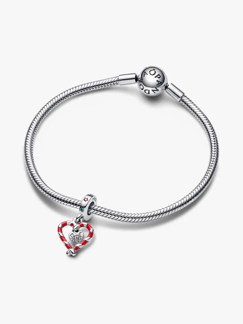 Three-quarter view of a silver bracelet with an enamel heart charm, on a white background.