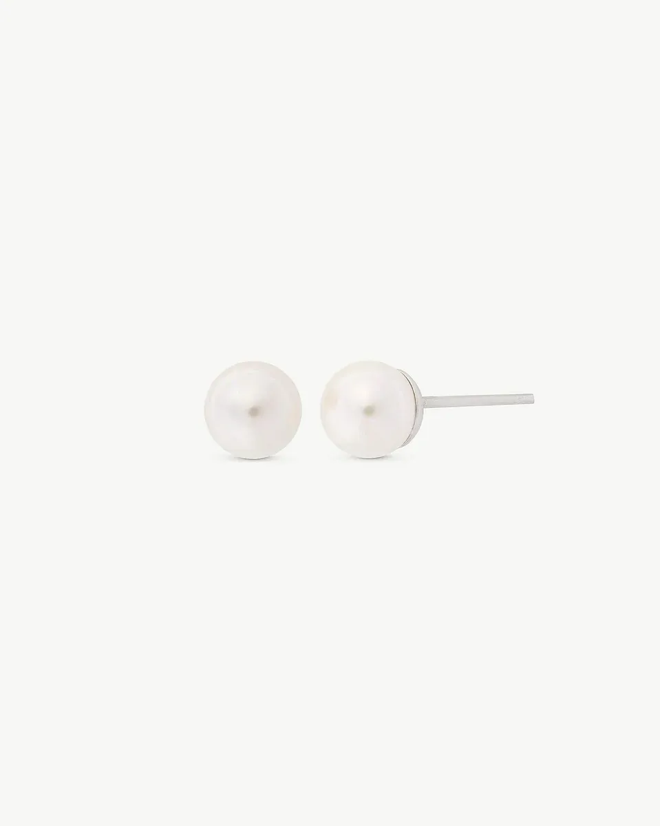 Vue de face des boucles d'oreilles en perles blanches sur fond blanc, montrant la tige latérale.