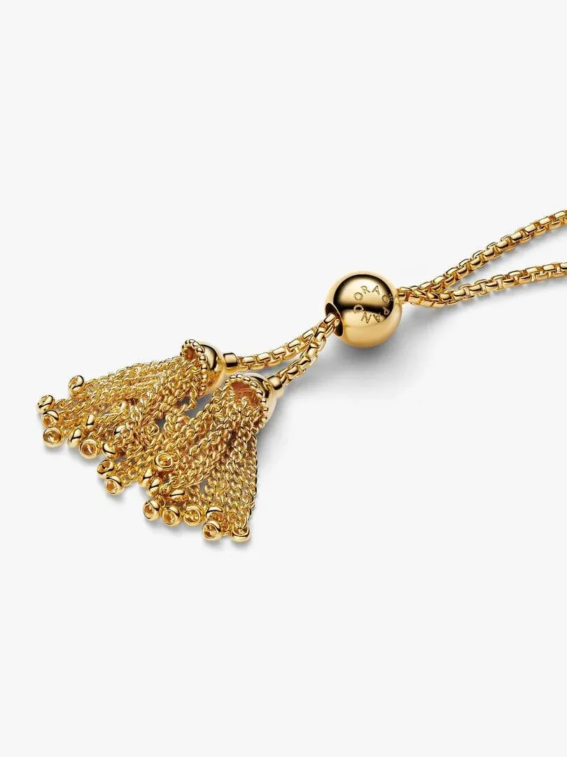 Close-up of the bracelet clasp featuring gold tassel charms and engraved bead on a white background.