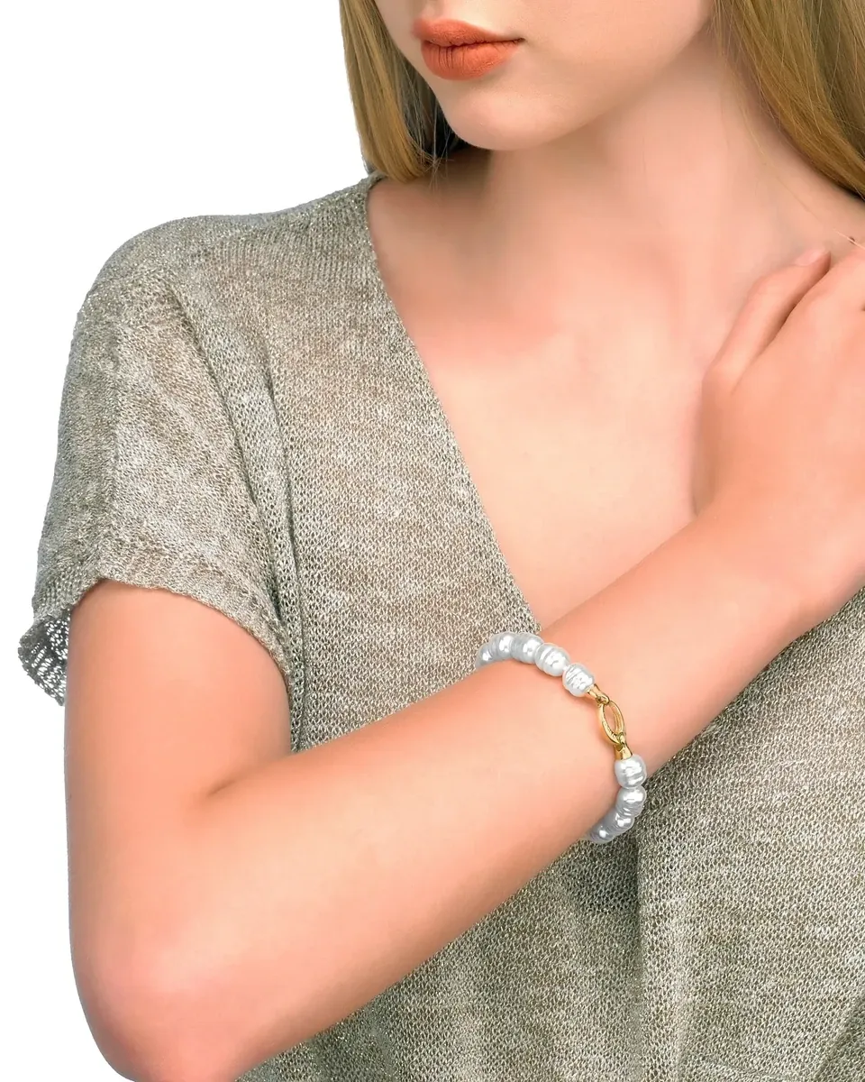 Bracelet worn on a female wrist, medium shot on white background with neutral-toned clothing.
