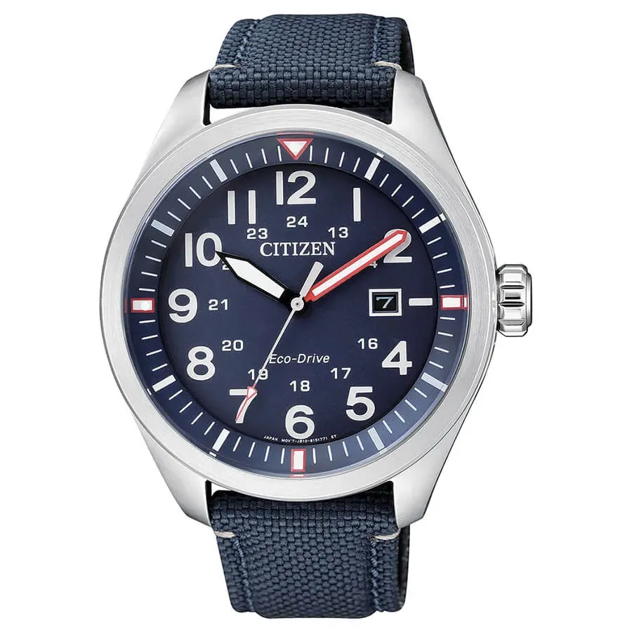 Vista frontal completa del reloj, esfera azul y correa textil, fondo blanco.