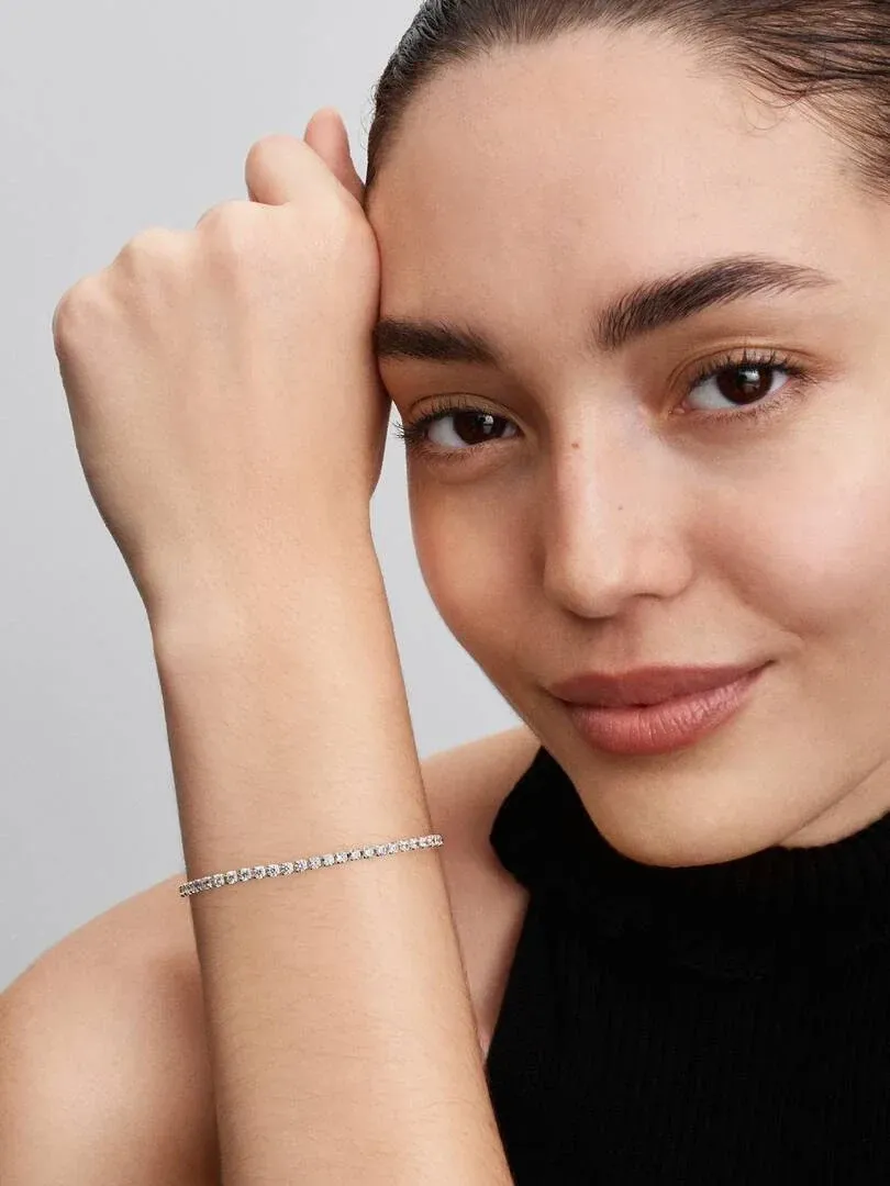 Close-up of the sparkling bracelet on a wrist, side view with model against a neutral background.