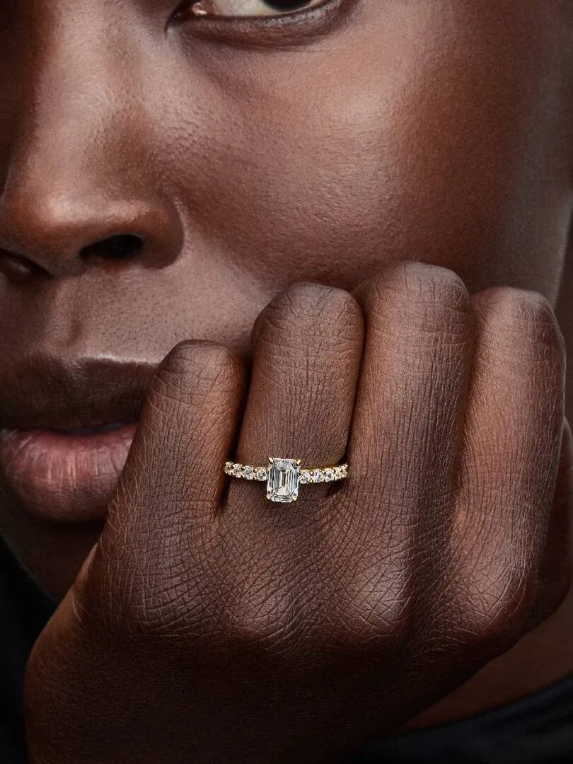 Nahaufnahme des Rings mit rechteckigem Stein am Finger, Seitenansicht neben dem Gesicht.