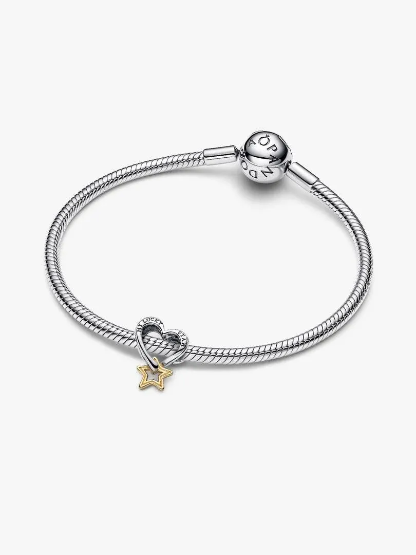 Pulsera de plata con charms de estrella dorada y corazón, vista lateral sobre fondo blanco.