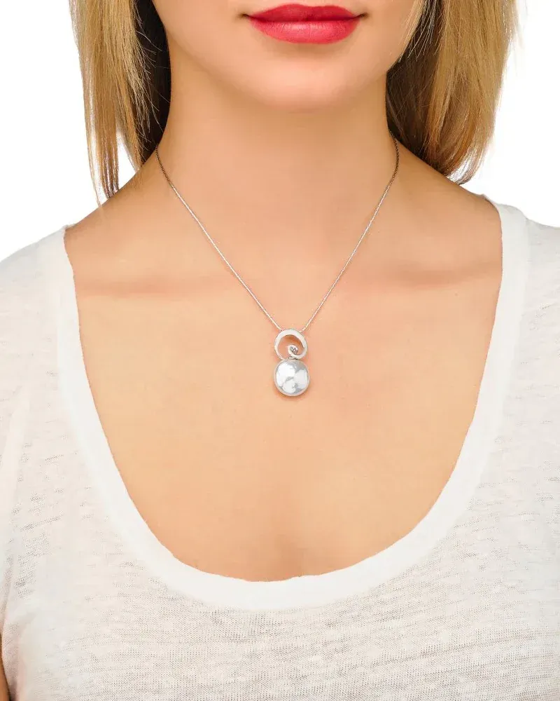 Collier porté au cou d'un mannequin, vue de face, fond neutre et t-shirt blanc.
