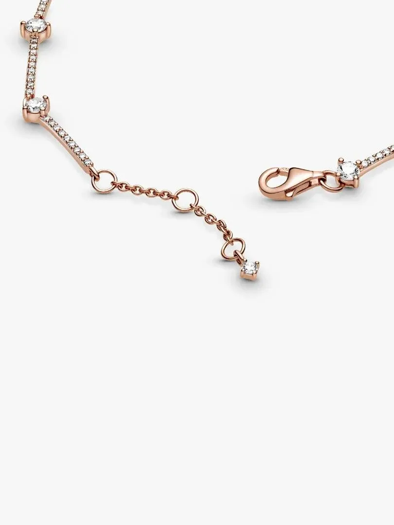 Nahaufnahme des roségoldenen Karabinerverschlusses und der Kette auf weißem Hintergrund.