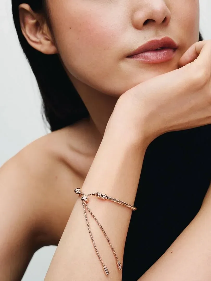 Nahaufnahme des Armbands mit Schiebeverschluss am Handgelenk, Seitenansicht vor neutralem Hintergrund.